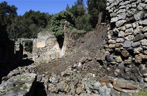 Bricks and rocks are seen on the ground after a section of wall around an ancient shop collapsed in Pompeii as a consequence of a rainstorm, Monday, March 3, 2014.   (AP Photo/Salvatore Laporta)